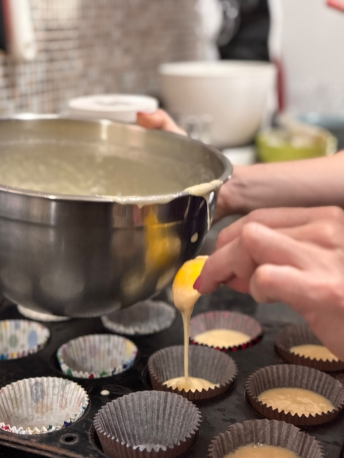 Massa de cupcake sendo distribuída nas forminhas