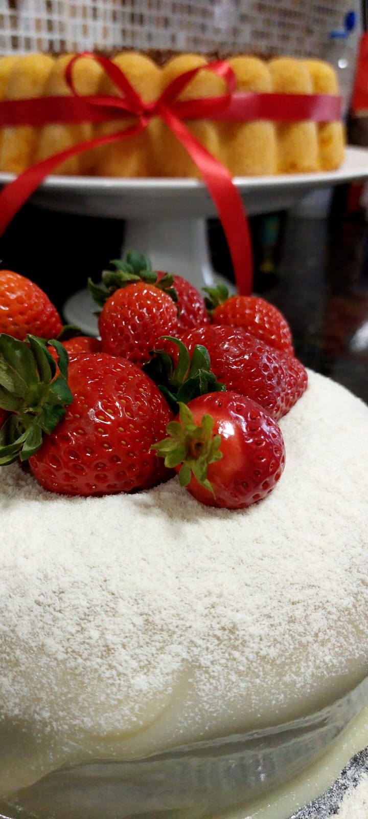 Bolo branco coberto de leite em pó com morangos frescos
