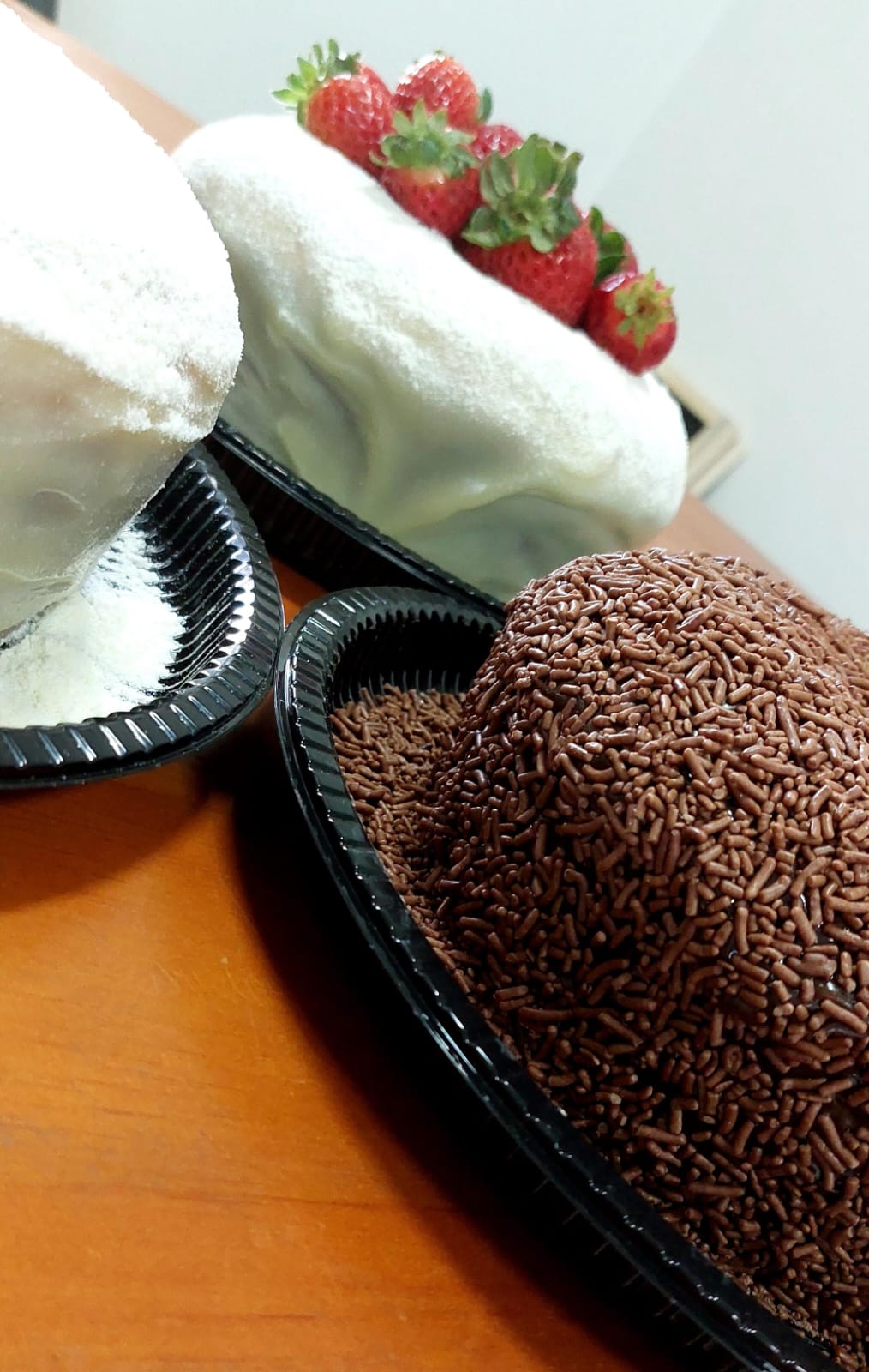Bolos brancos e bolo de brigadeiro prontos lado a lado