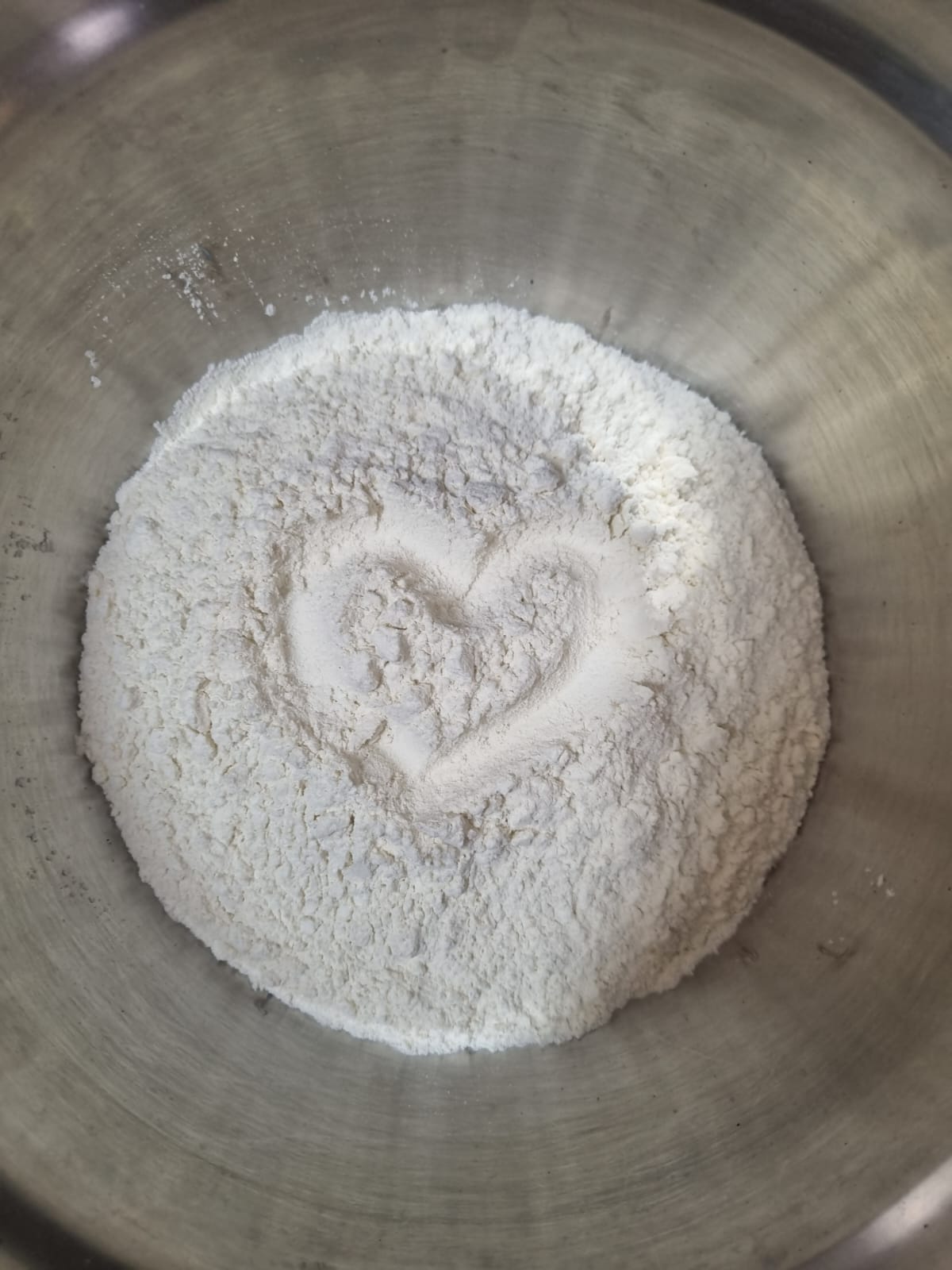 Farinha peneirada com um coração desenhado