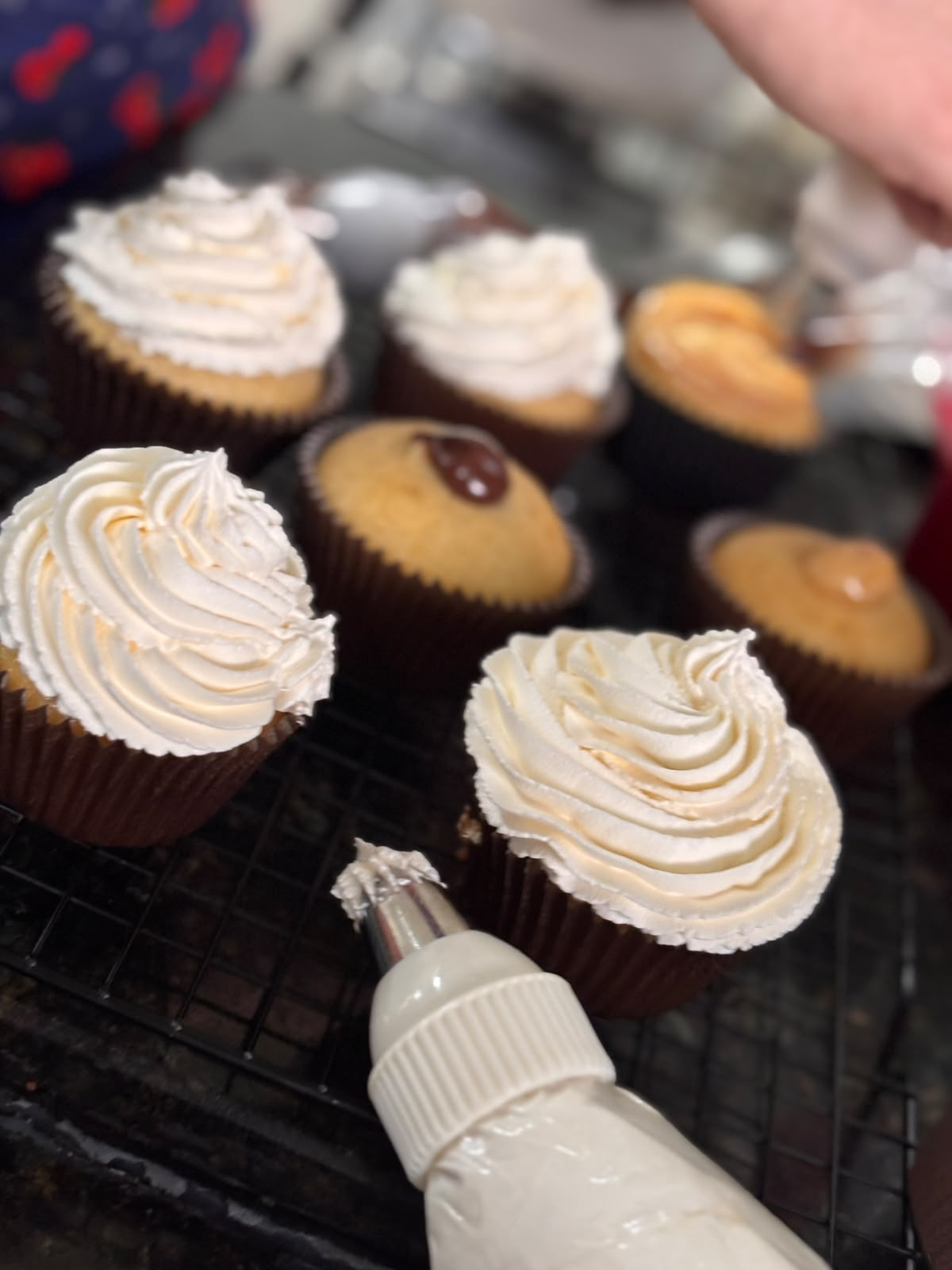 Cupcakes recebendo cobertura de creme branco