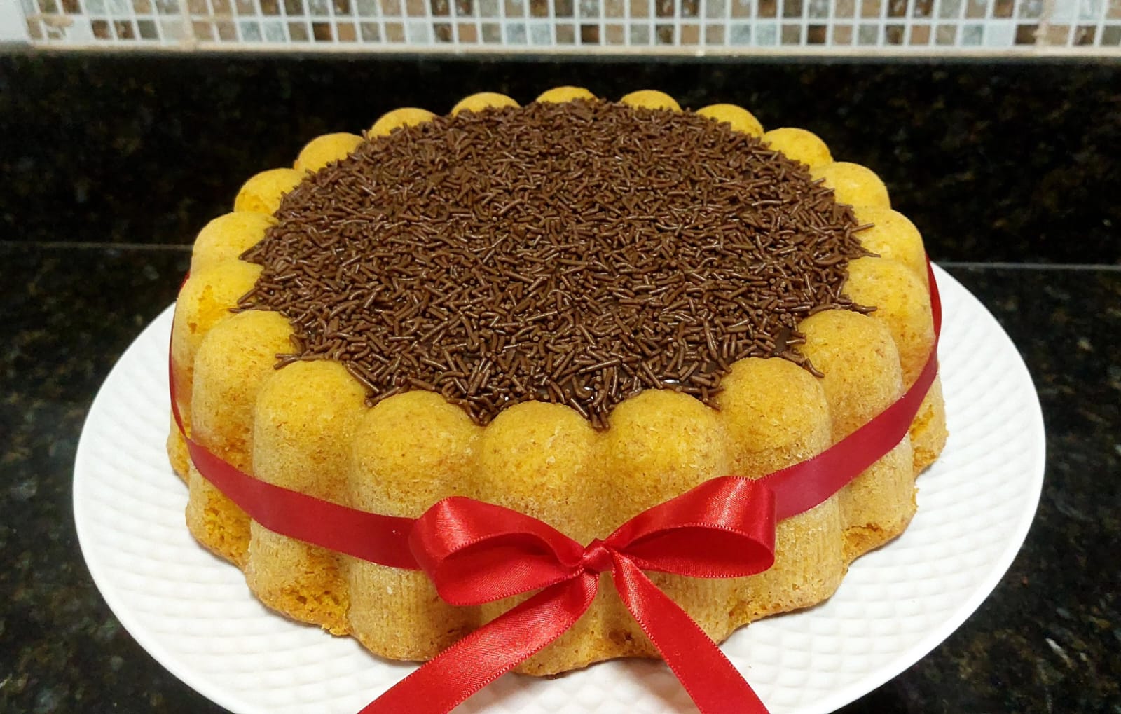 Bolo com laterais de biscoito e brigadeiro no topo