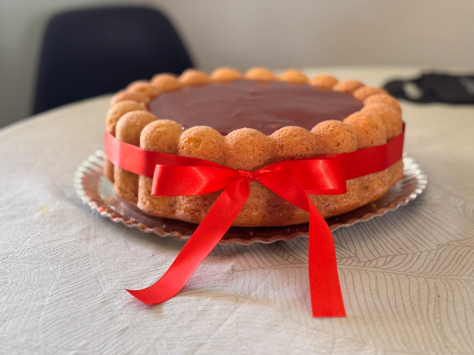 Bolo de festa com laço vermelho em uma mesa